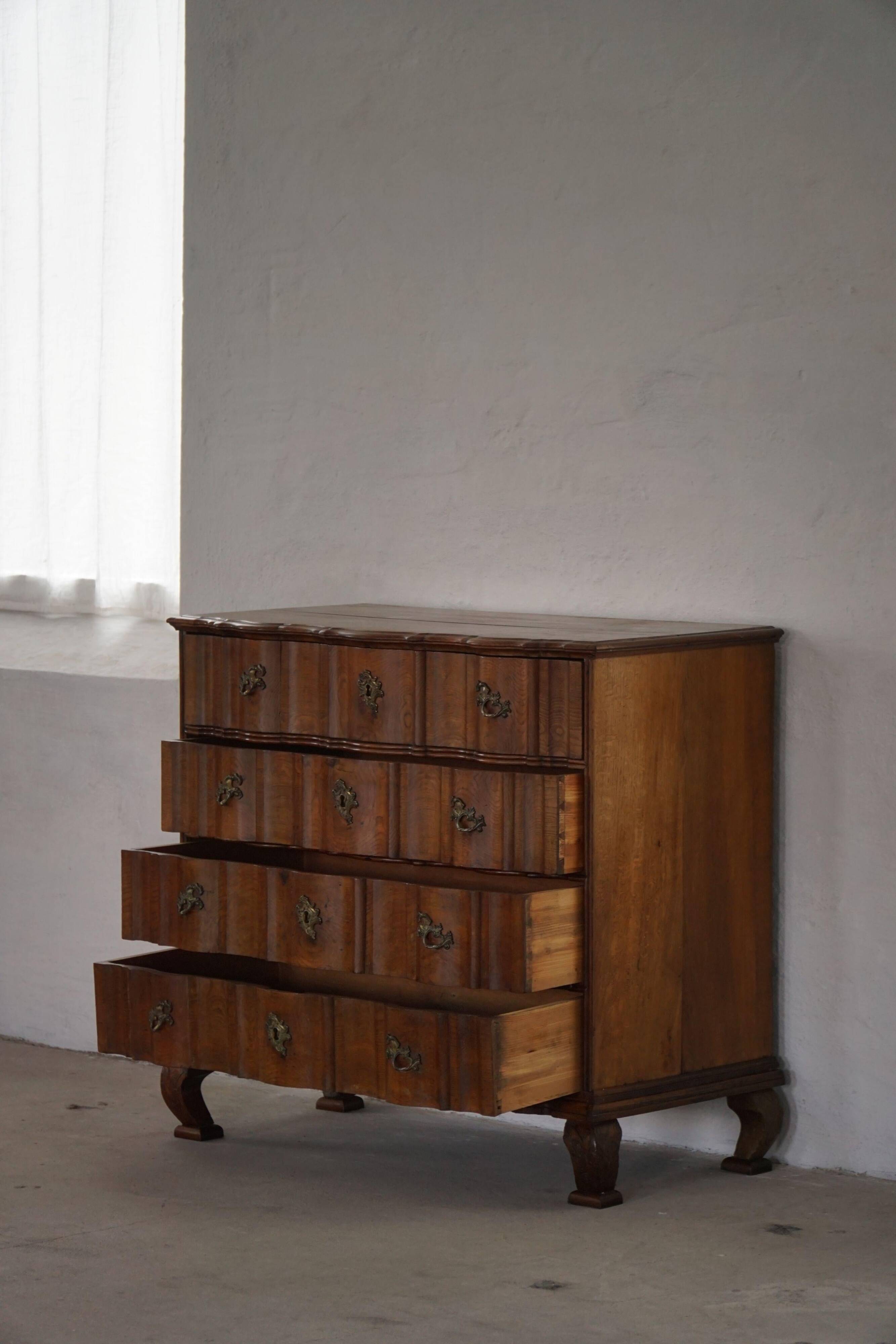 Antique baroque oak commode from the late 18th century with cabriole legs.
