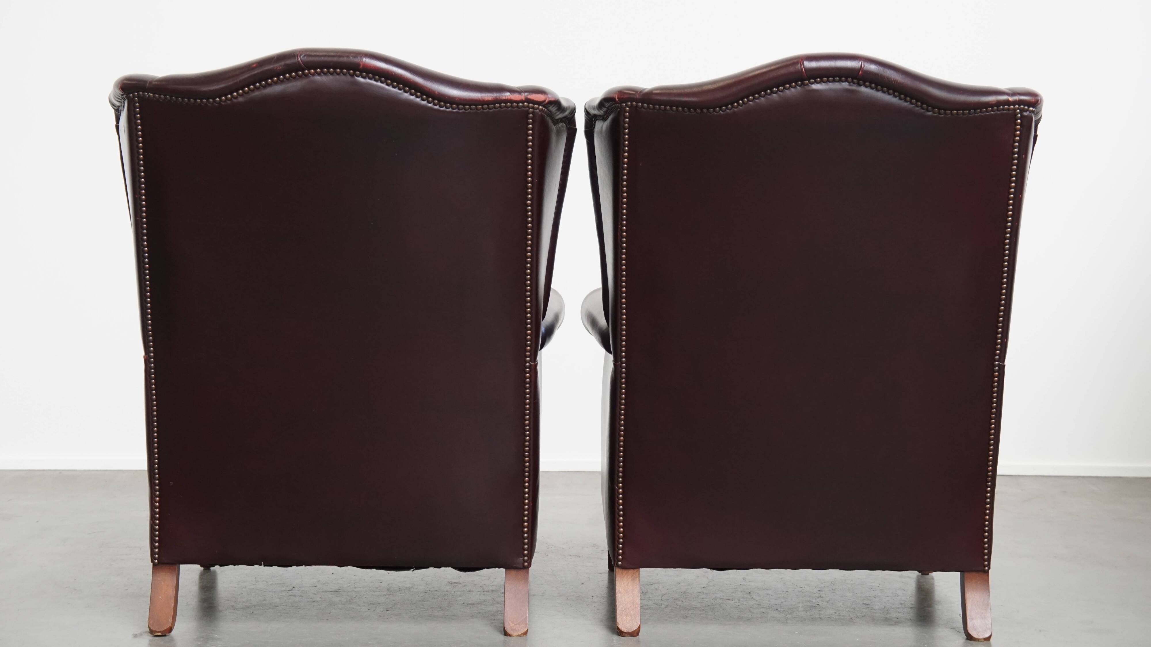 Ensemble de 2 fauteuils à oreilles en cuir de vachette + pouf de style anglais