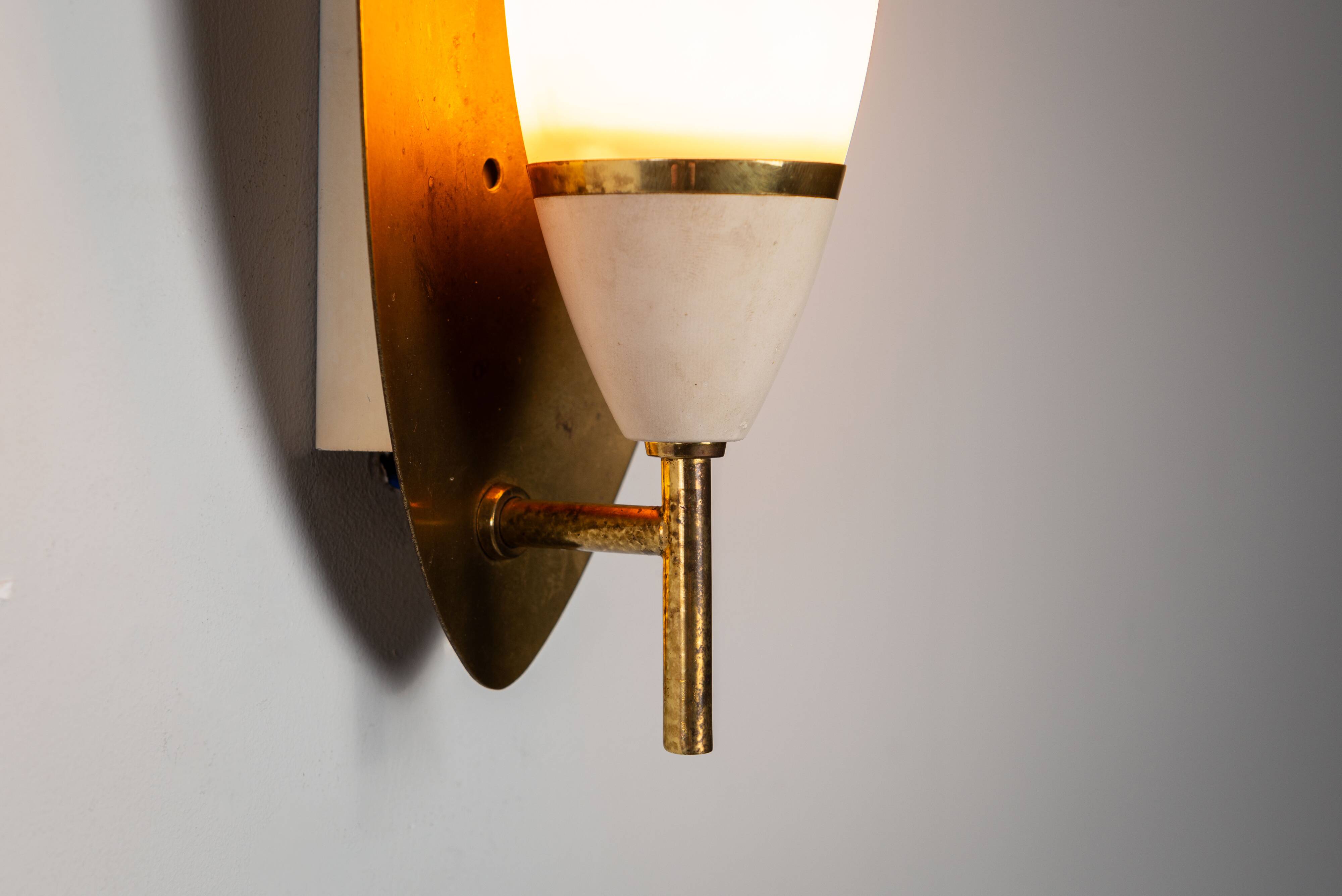 Pair of wall lamps with brass shields and glass shades