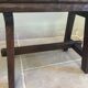 Small antique wooden bench with a folding backrest.