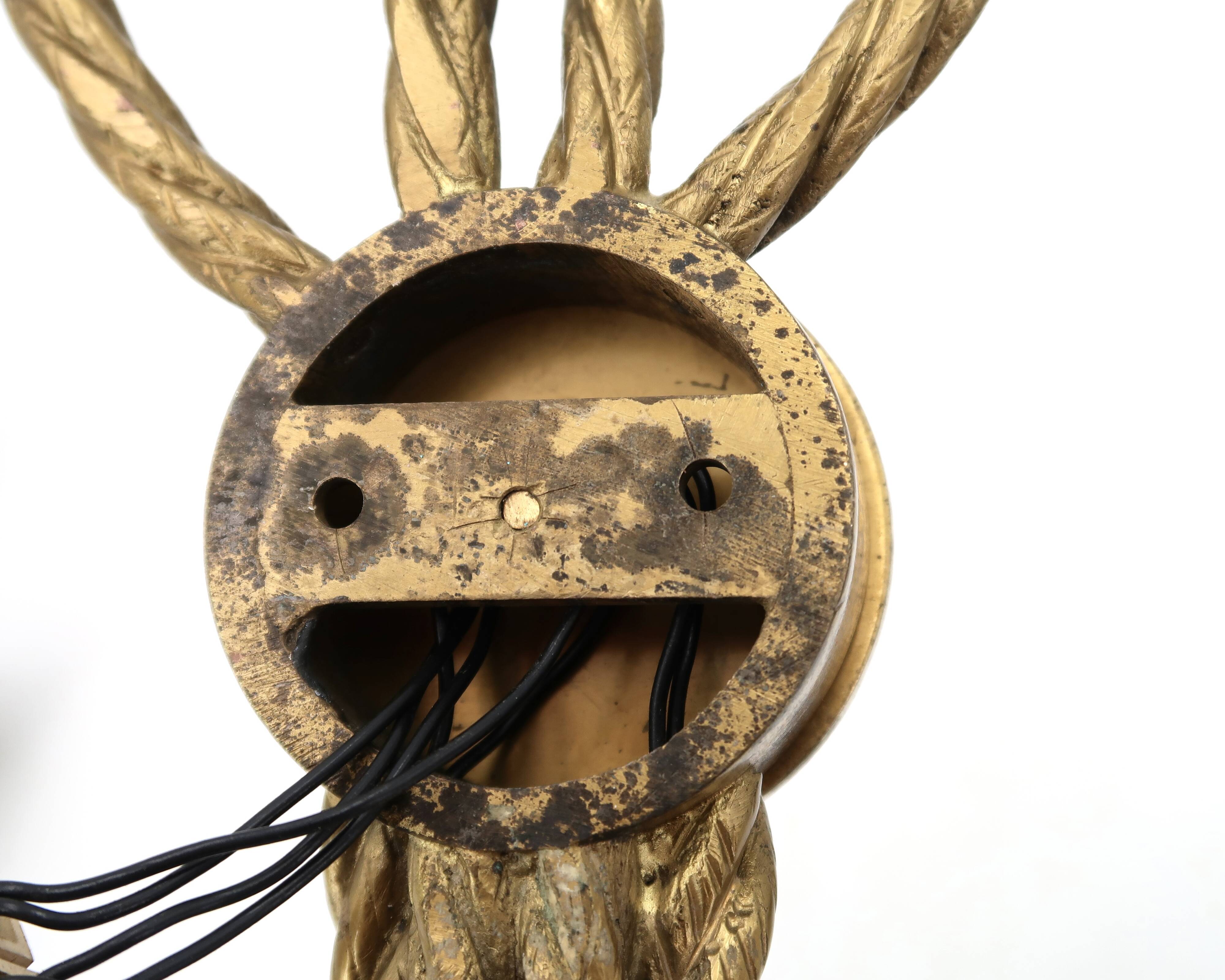 Golden wall lamp with two arms, decorated with a twisted rope bow, 1950s.