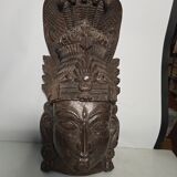 Ancient Indian carved wooden mask sculpture of a deity with a cobra.