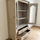 Antique beige wooden display cabinet with glass doors.