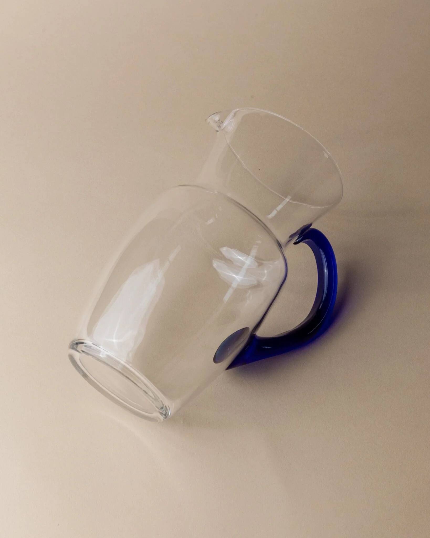 Vintage glass pitcher - clear glass with blue handle - Mid-Century design from Italy in the 1970s - elegant table decoration, retro gift idea.