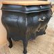 Curved commode painted in black and wood.