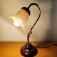 Gold swan neck table lamp with amber tulip glass.