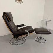 Vintage leather reclining armchair and its 1970s designer ottoman.