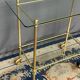 Service trolley on wheels with two glass shelves and a brass frame.