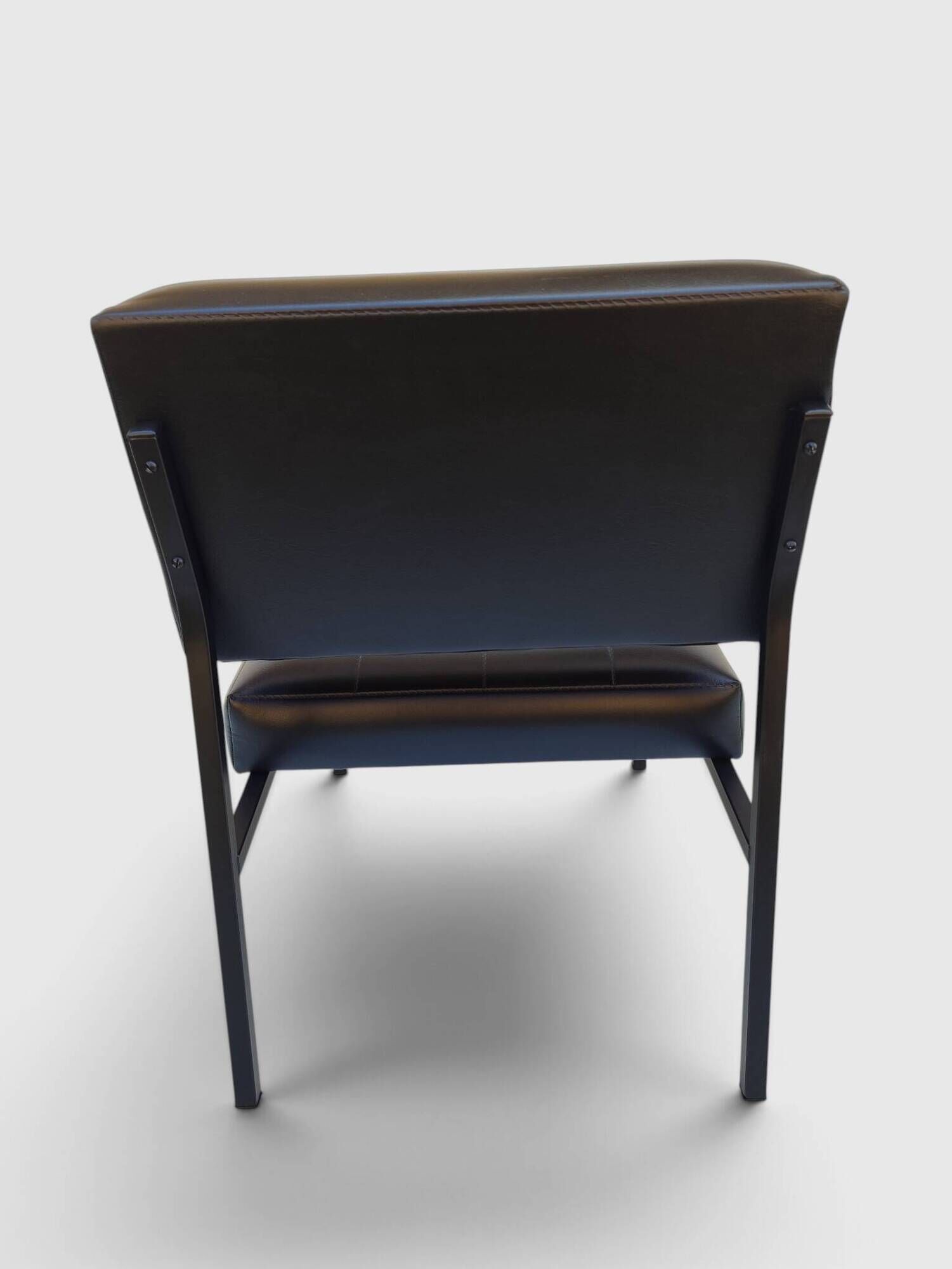 Modernist armchair in black faux leather and metal – 1960s