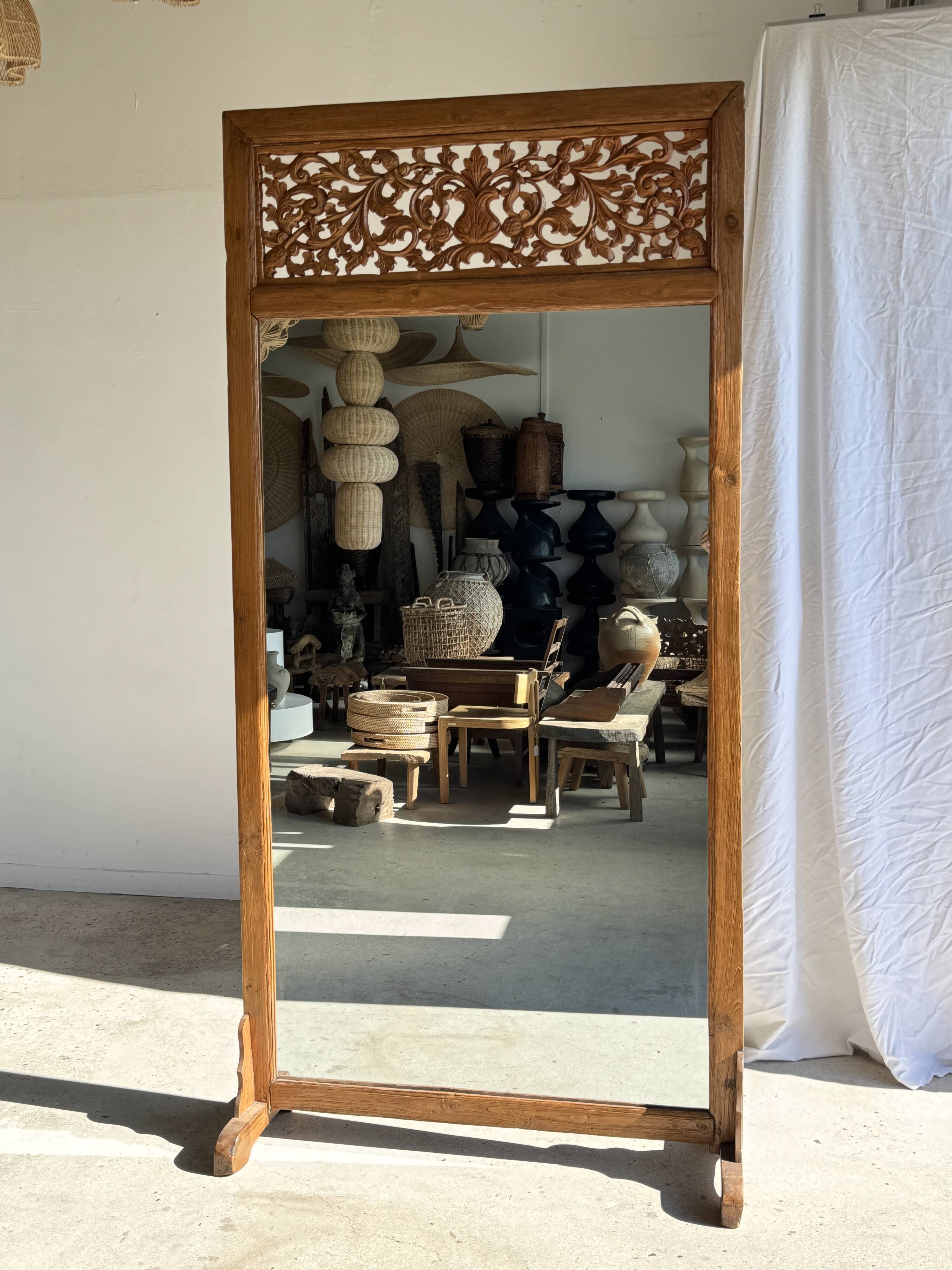 Very large freestanding teak mirror with an openwork carved pediment, Indonesia.