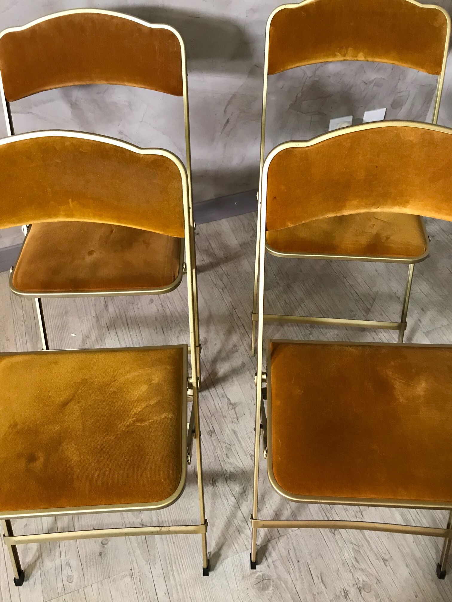 Four folding velvet and brass chairs