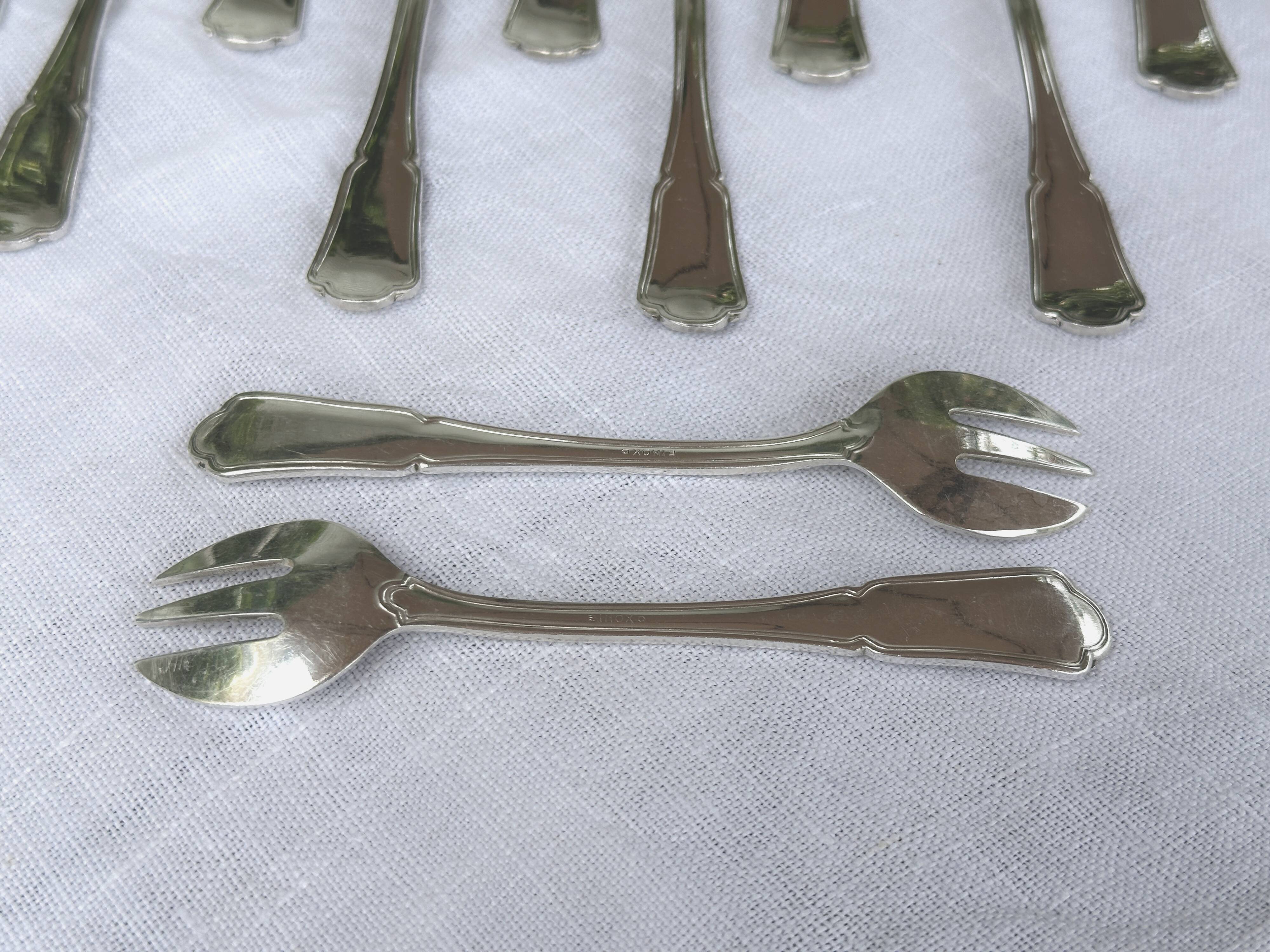12 silver-plated oyster/dessert forks, filet pattern with contours.