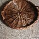 Large round dark wicker tray with two handles.