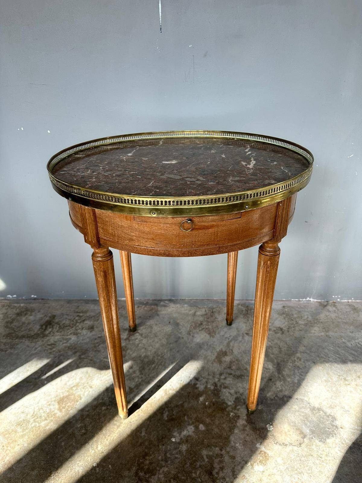 Hot water bottle table with a marble top and a brass gallery.