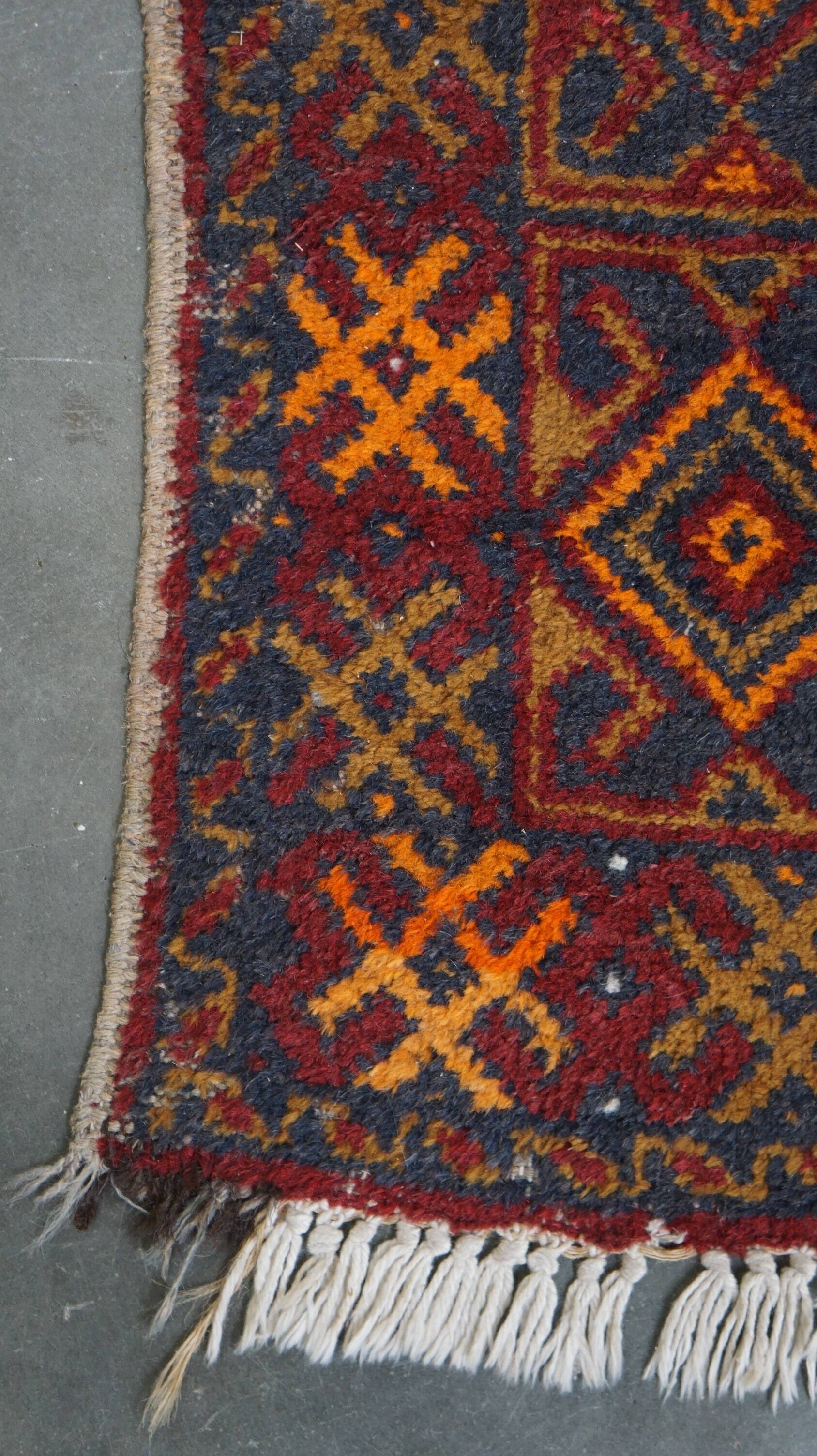 Antique oriental rug featuring orange details 135x81cm