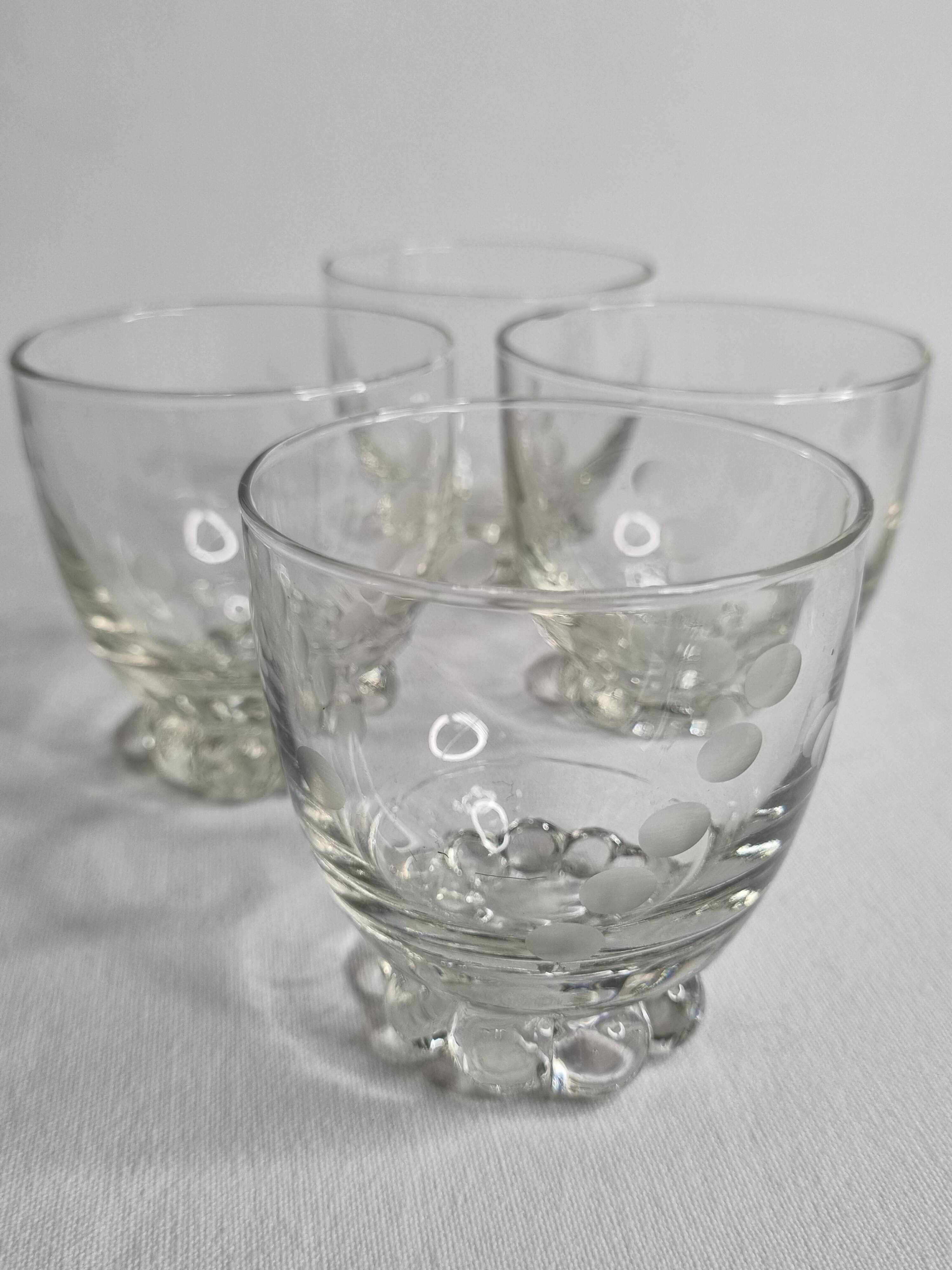 Set of four Art Deco style engraved crystal glasses on spherical feet