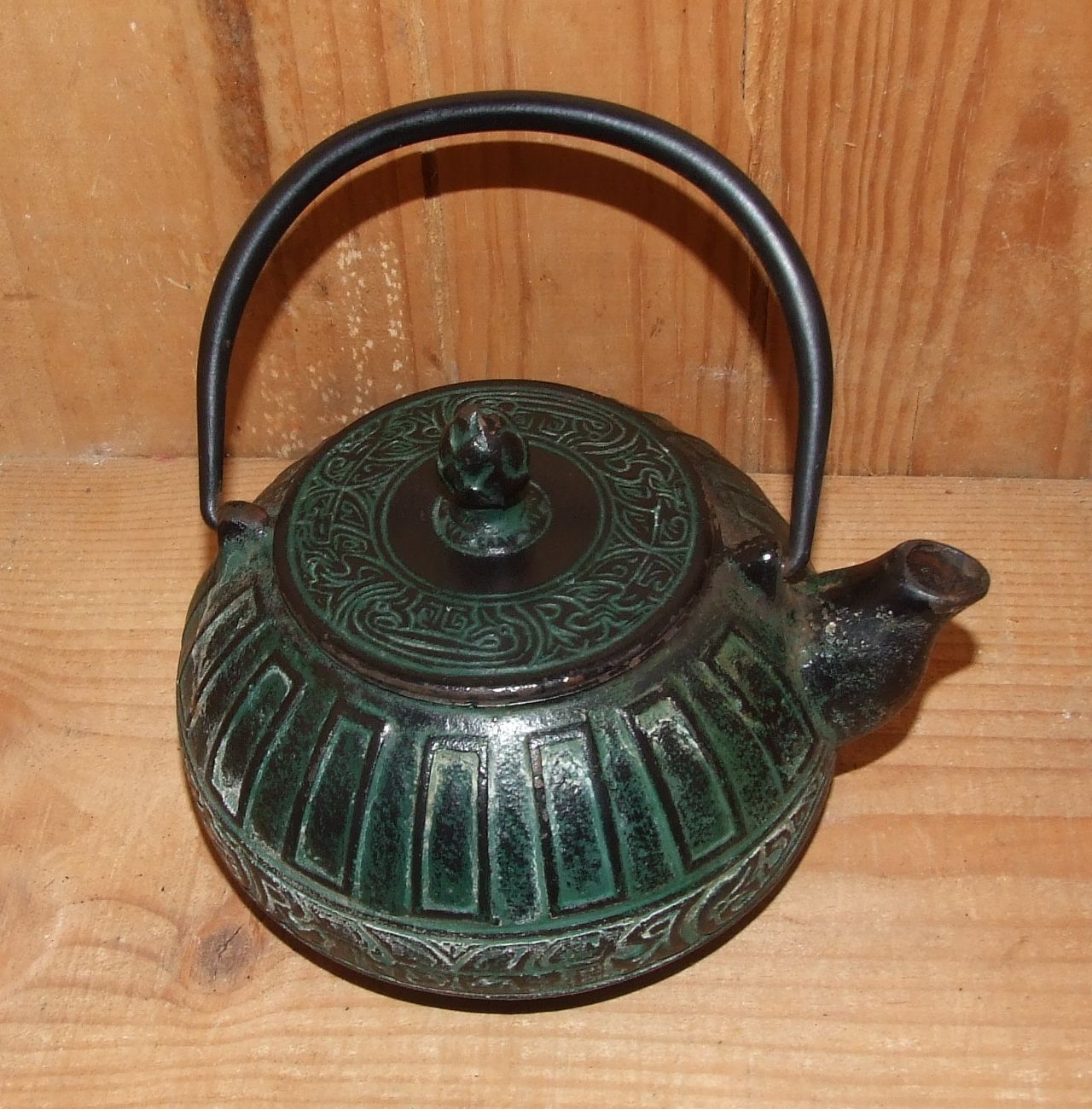 Japanese teapot in patinated green cast decorated with motifs
