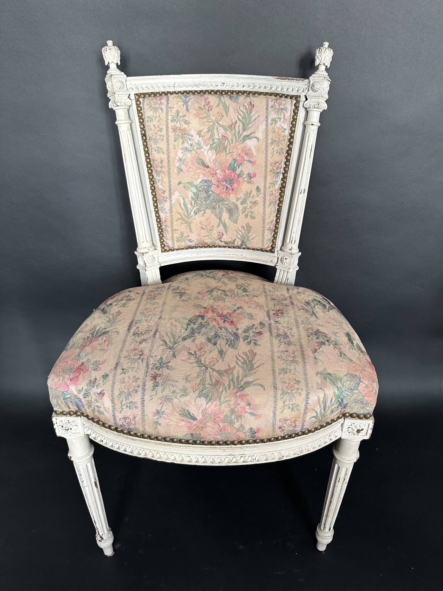Antique Louis XVI style chair with patinated wood and floral fabric.