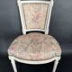 Antique Louis XVI style chair with patinated wood and floral fabric.