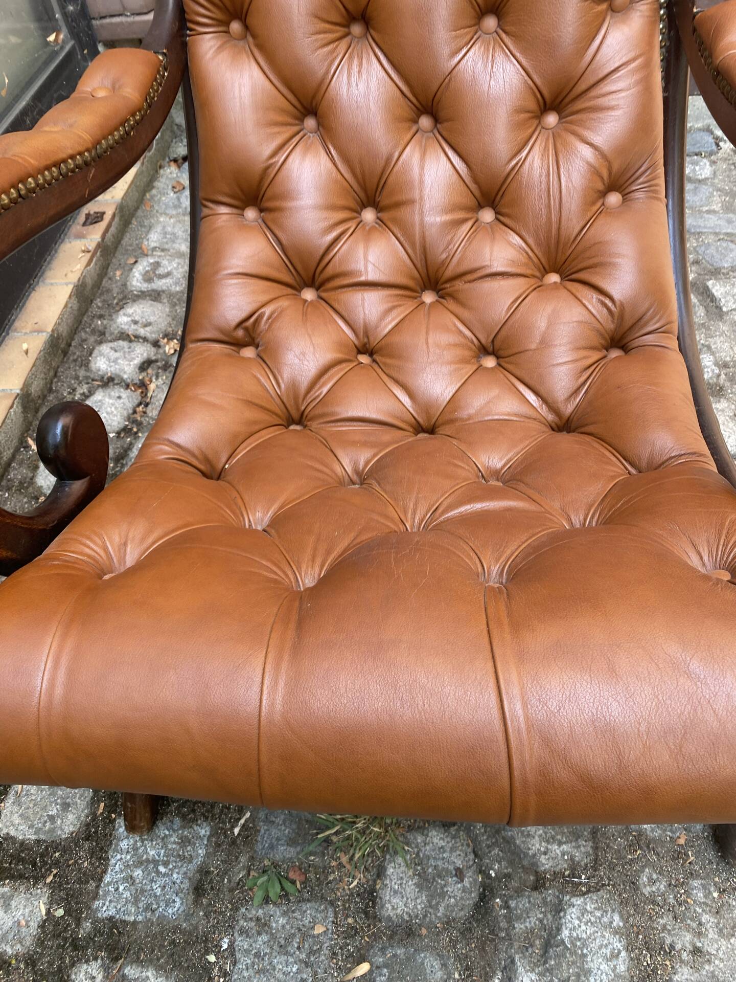 Chesterfield armchair in leather and carved solid wood