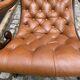 Chesterfield armchair in leather and carved solid wood
