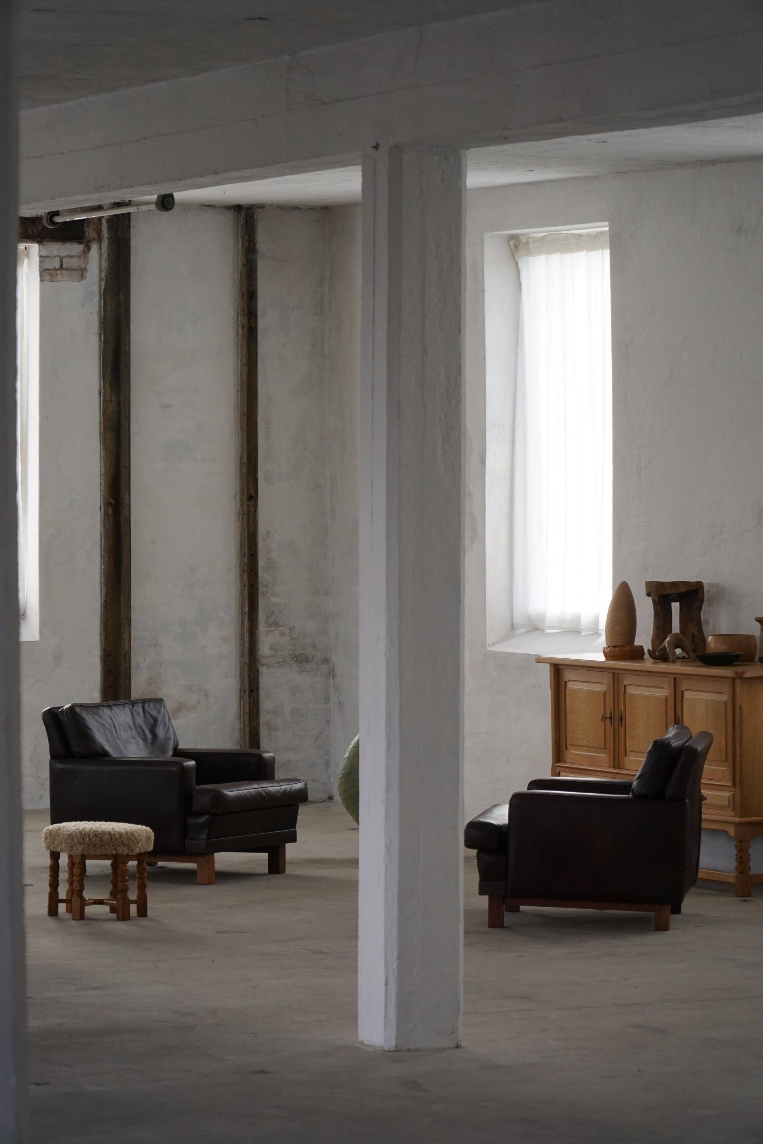 Pair of modern Danish lounge chairs in dark brown leather and rosewood, 1960s.