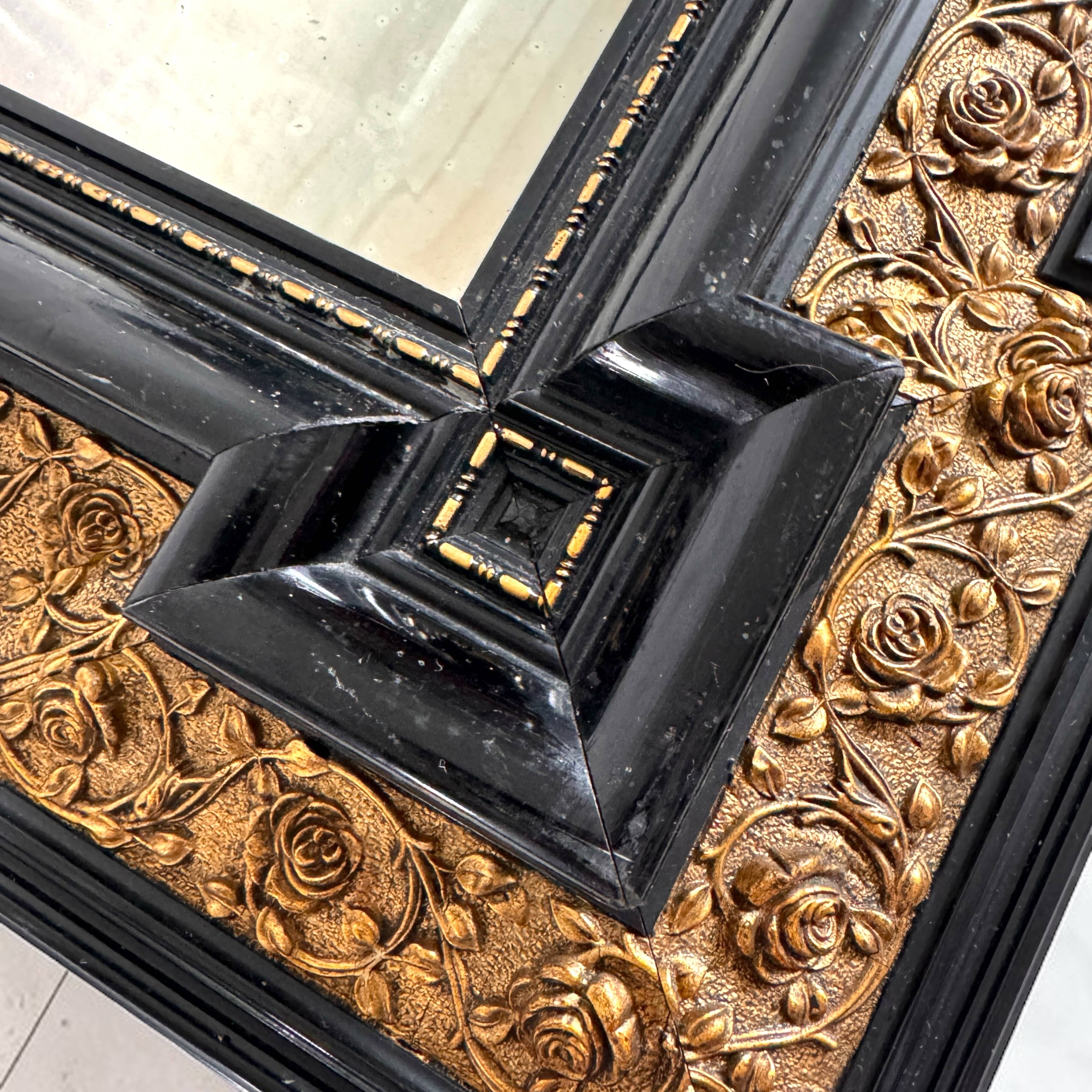 Antique wall mirror in blackened wood and gilded stucco, 19th-century Dutch style.