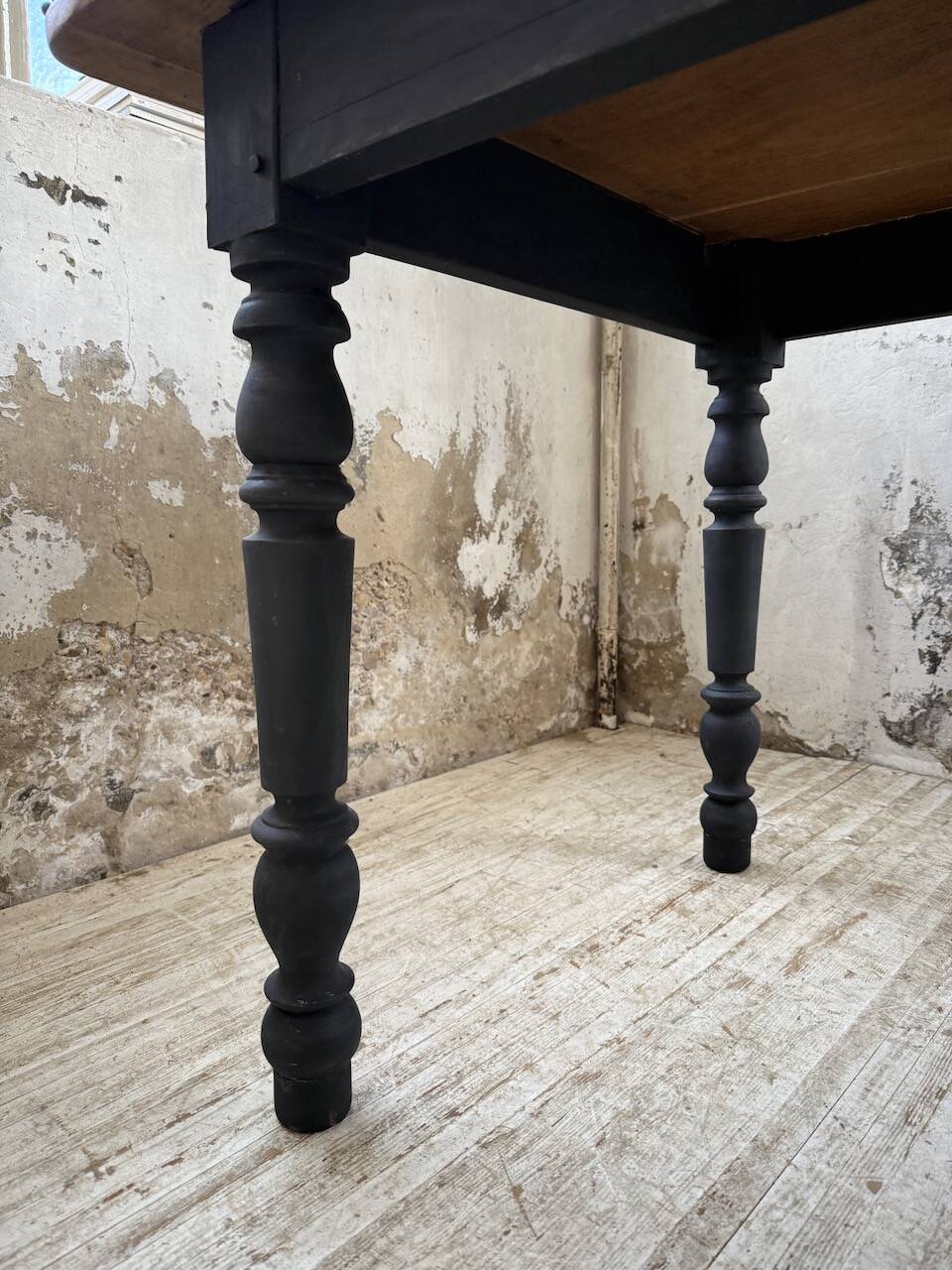 Oak farmhouse table with turned black legs.