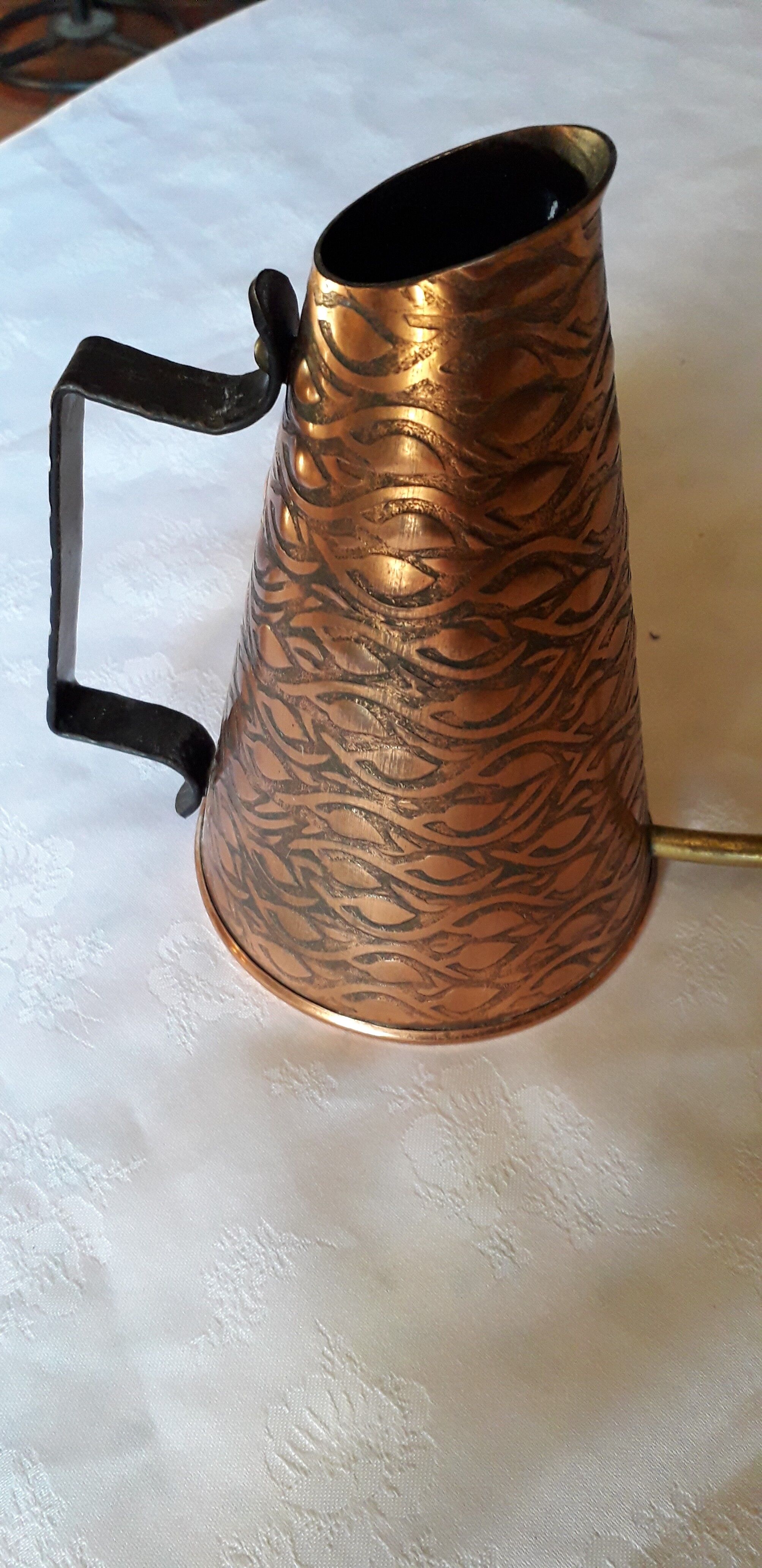 Old watering can in red copper and brass