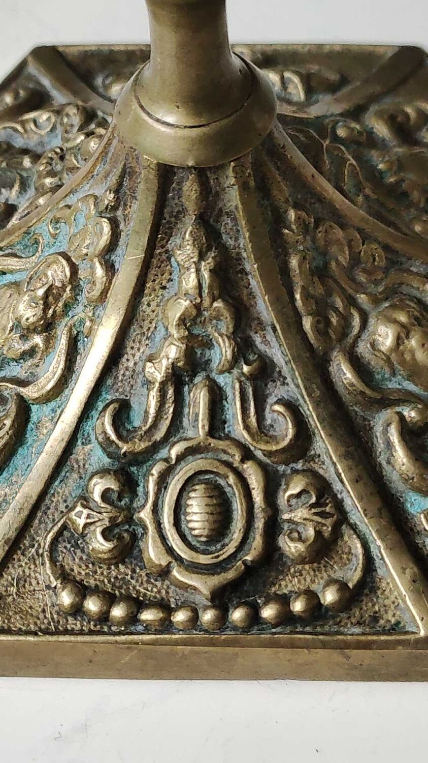 Baroque/Antique style torch candleholder, nineteenth, gilded bronze. Head motifs, volute arabesques