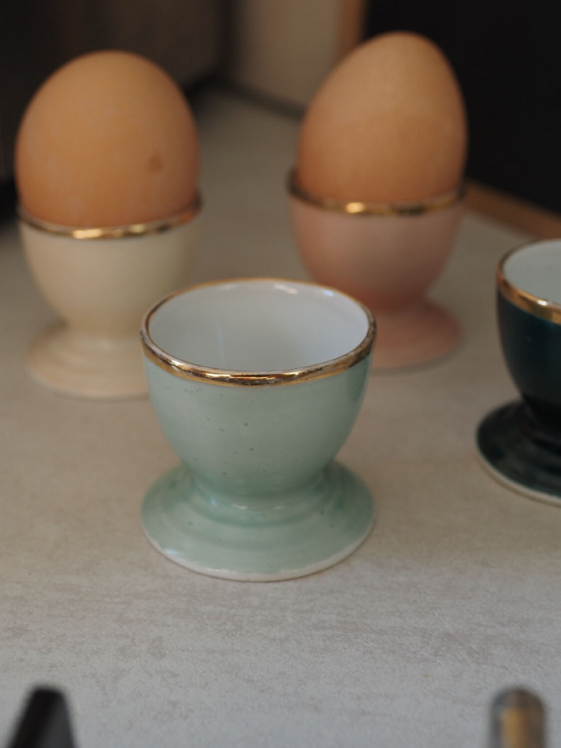 Four coloured egg cups with a golden rim from the 50s.