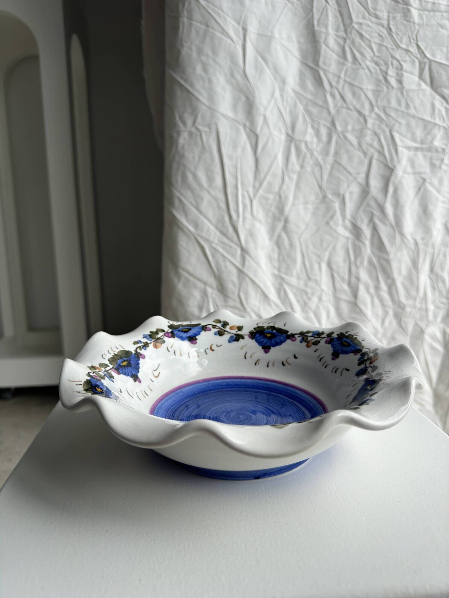 Small hand-painted earthenware salad bowl with garland of blue flowers, mark below