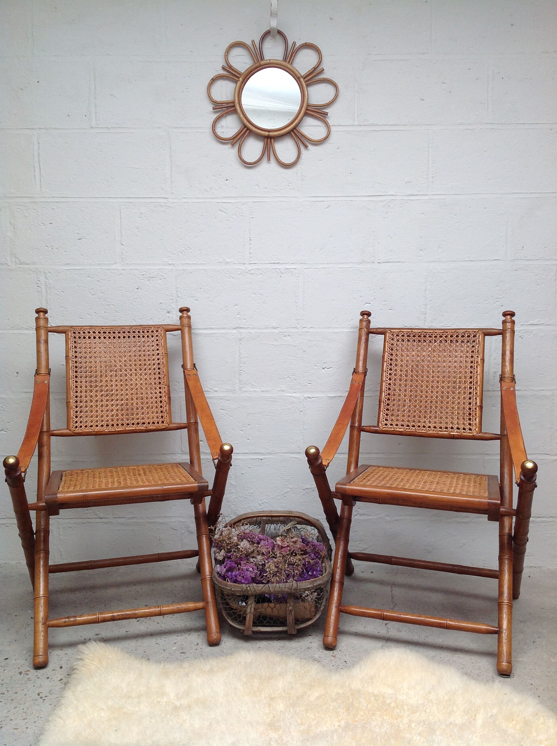 Pair of folding chairs in bamboo and caning, leather and brass