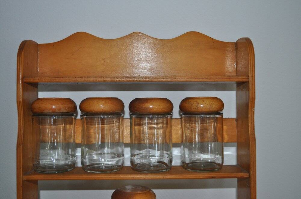 Brown wooden wall spice rack with a set of 6 glass jars, 1950s vintage style.