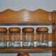 Brown wooden wall spice rack with a set of 6 glass jars, 1950s vintage style.