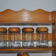 Brown wooden wall spice rack with a set of 6 glass jars, 1950s vintage style.