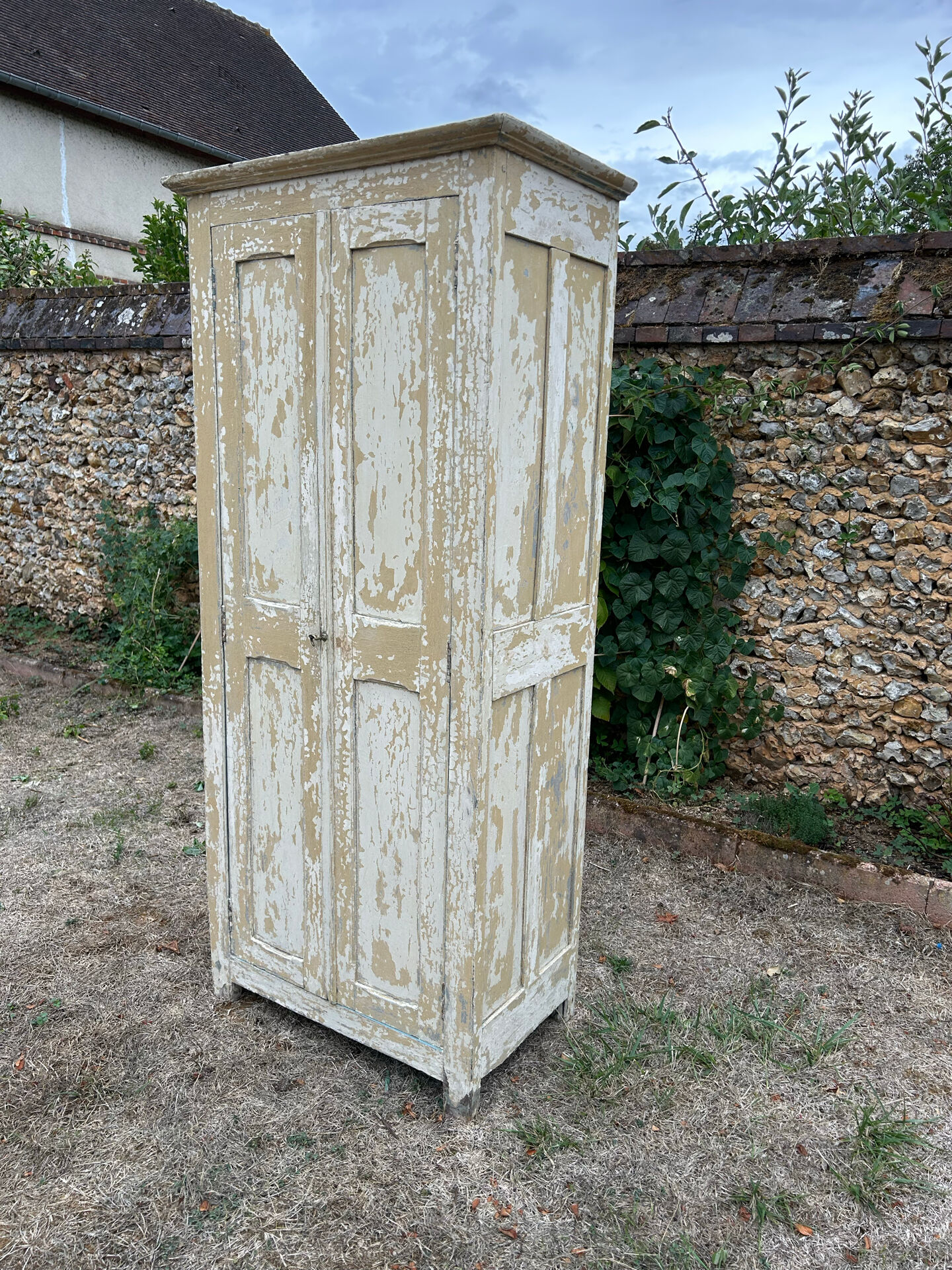 Small antique wardrobe with a faded white patina.