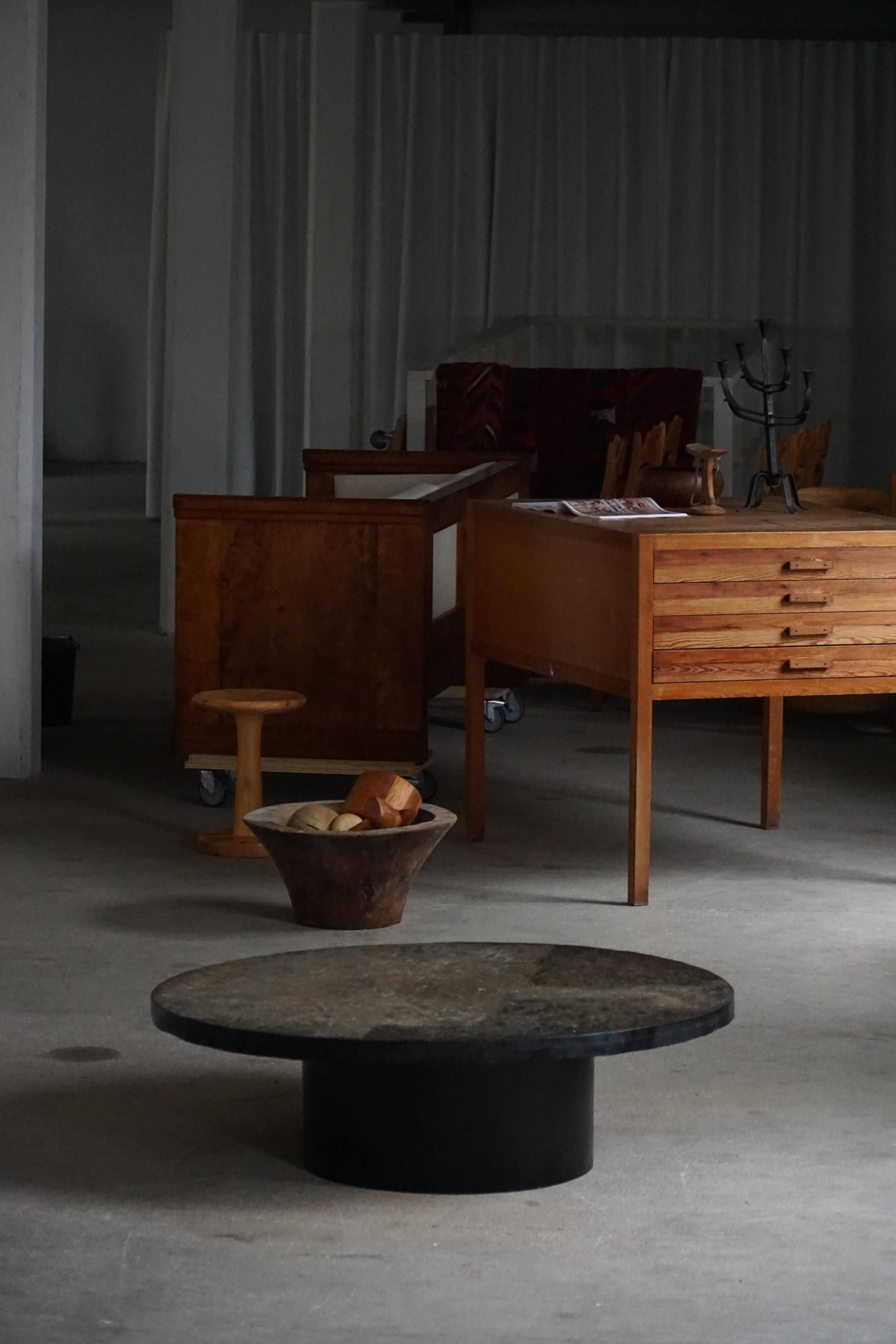 Round brutalist coffee table in stone and steel, mid-century French modernism, 1970s.