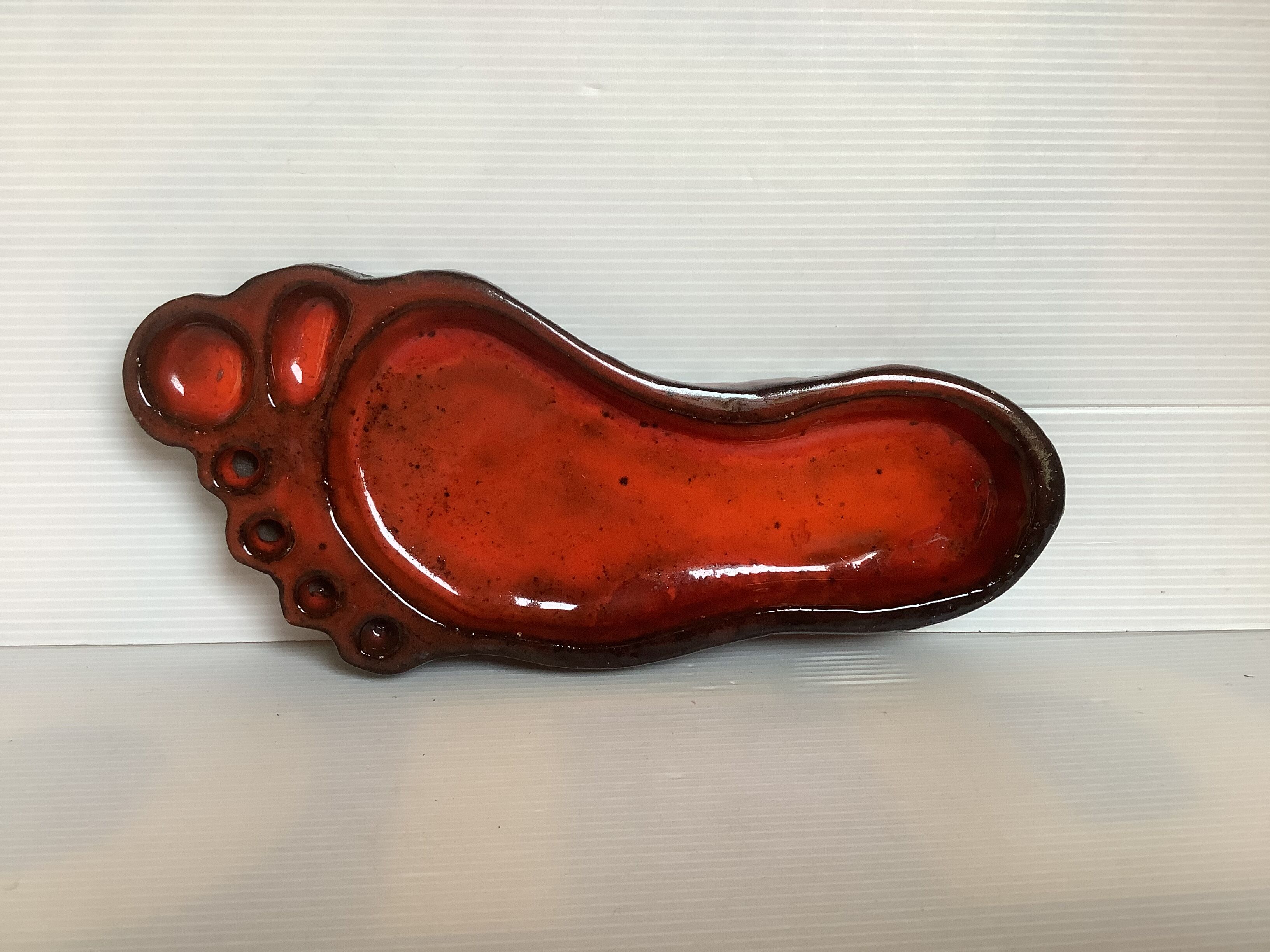 Red ceramic footprint catchall.