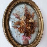 Golden vintage frame with bouquet of dried flowers under globe, wedding bouquet, antique bouquet