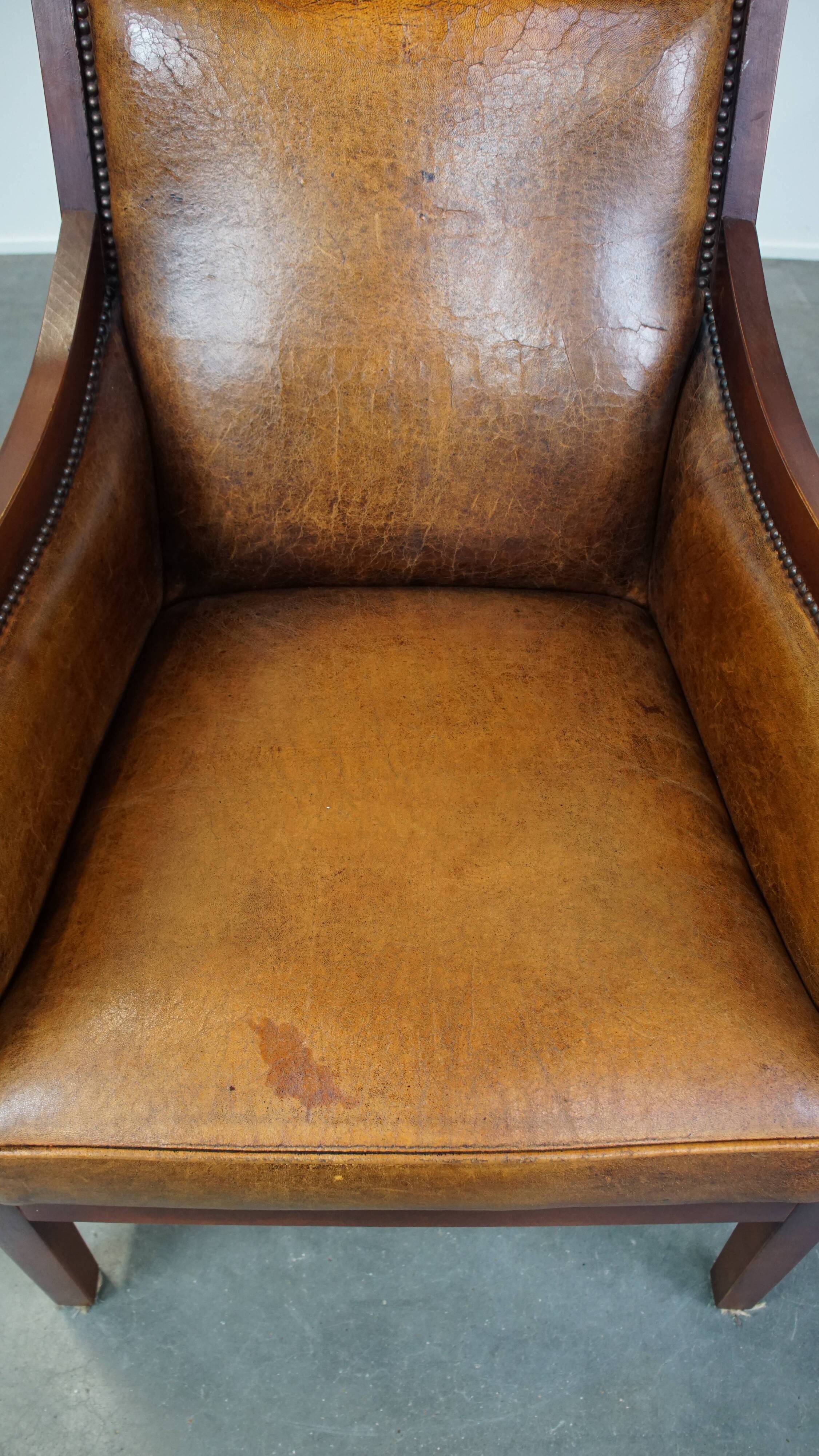 Sheepskin and wooden vintage Art Deco design armchair in a cognac color