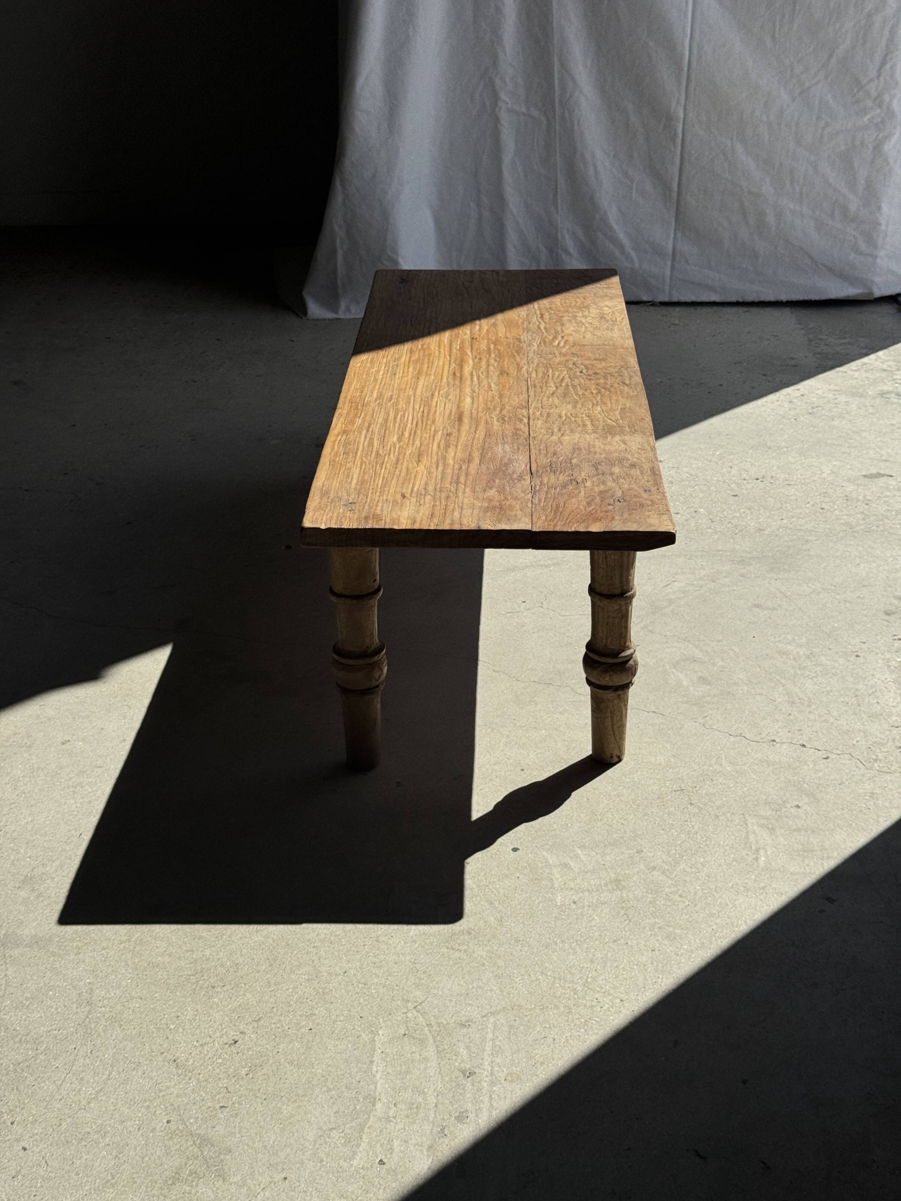 Brown Indonesian teak coffee table, with a border and cylindrical legs H40 L103.