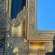 Baroque mirror in gilded wood on a black background.