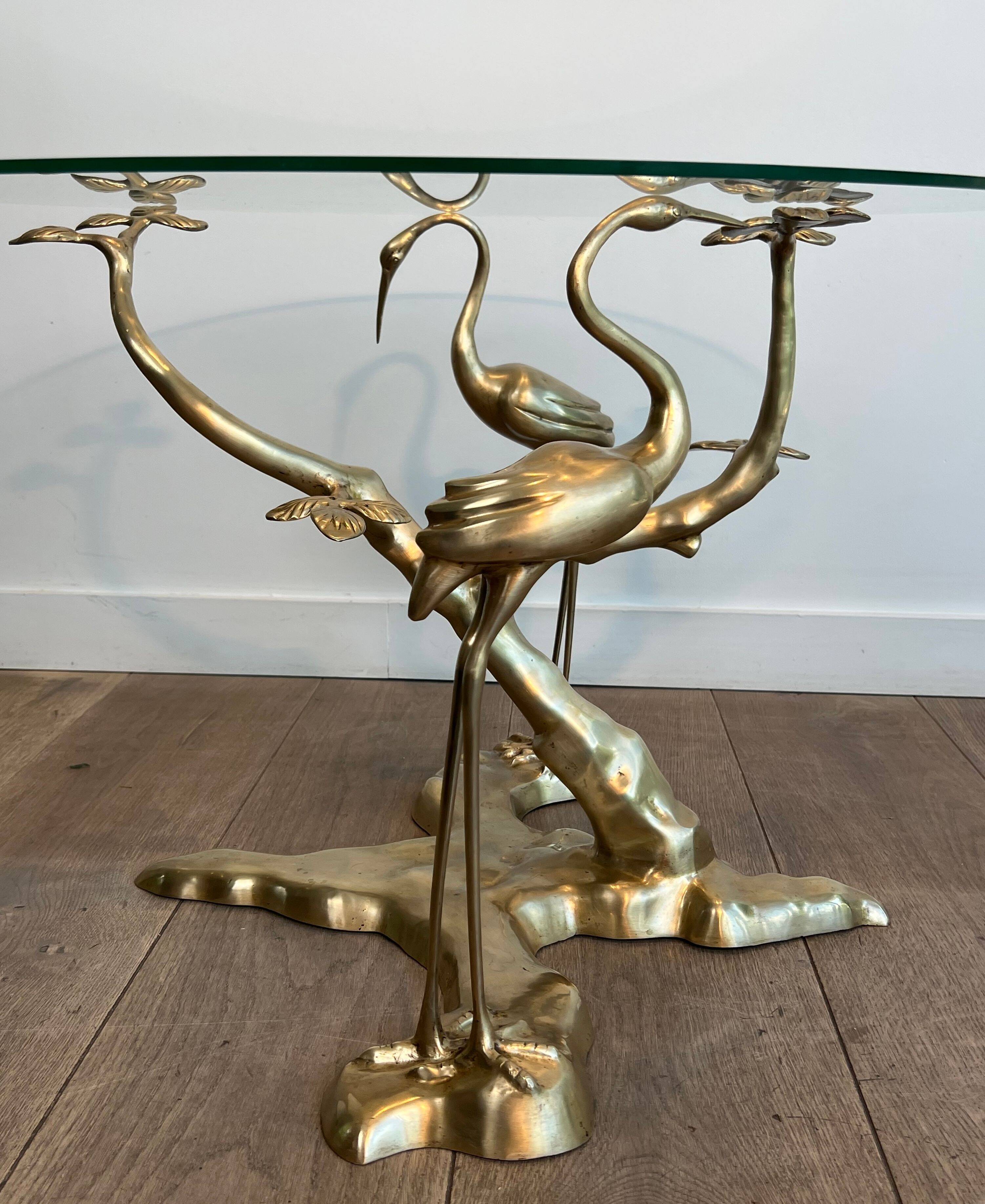 Coffee table model with cranes surrounding a brass bonsai and round glass top by Willy Daro.