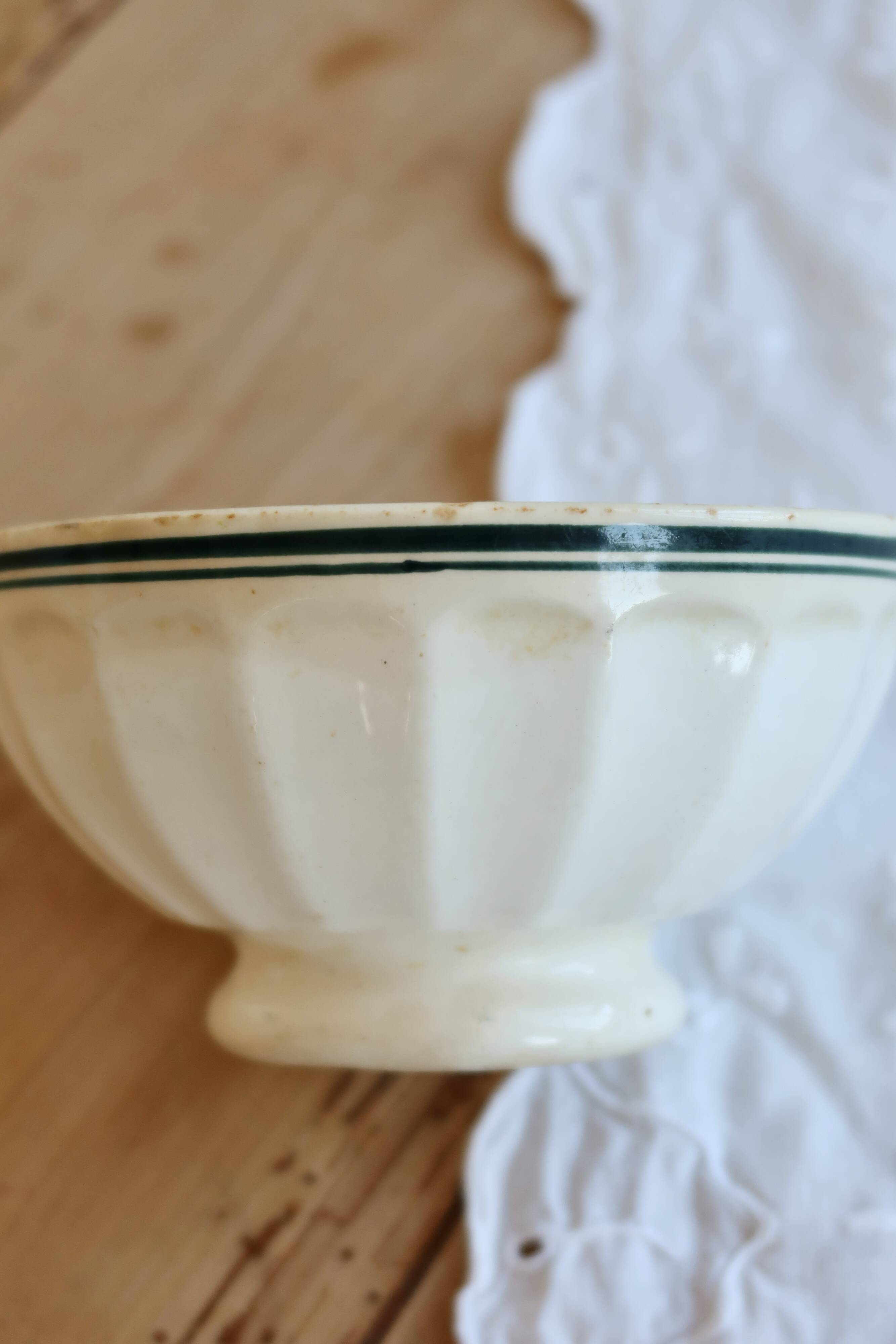 Old ivory ceramic bowl with double green trim.