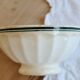 Old ivory ceramic bowl with double green trim.