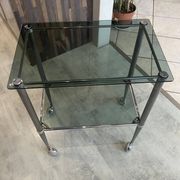Serving dessert trolley with 2 smoked glass shelves and metal structure.