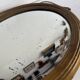 Antique oval mirror in gilded wood, bevelled mercury glass, 19th century.