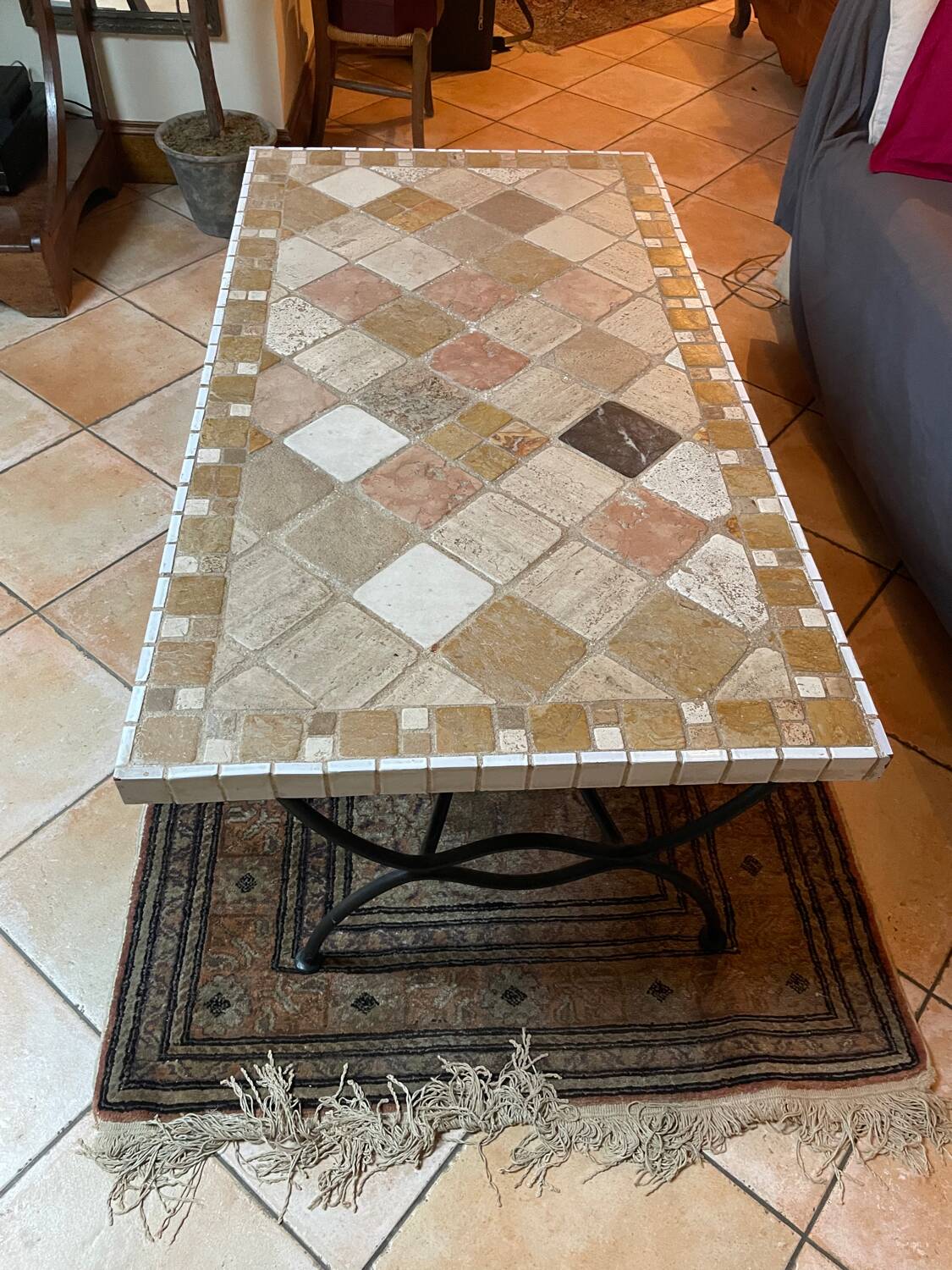 Beige ceramic coffee table with black metal legs.