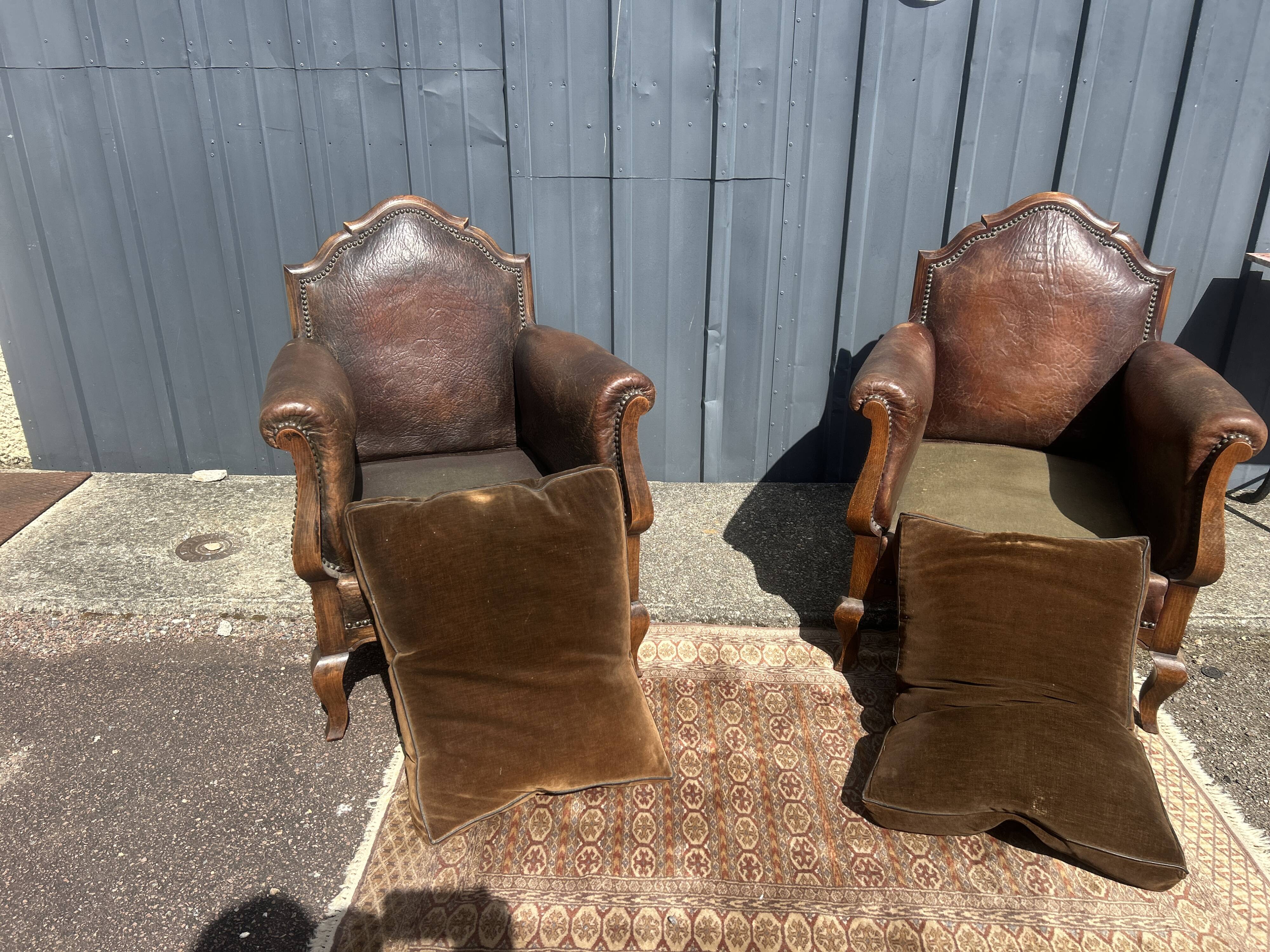 Pair of club armchairs in wood and leather, early 20th century.